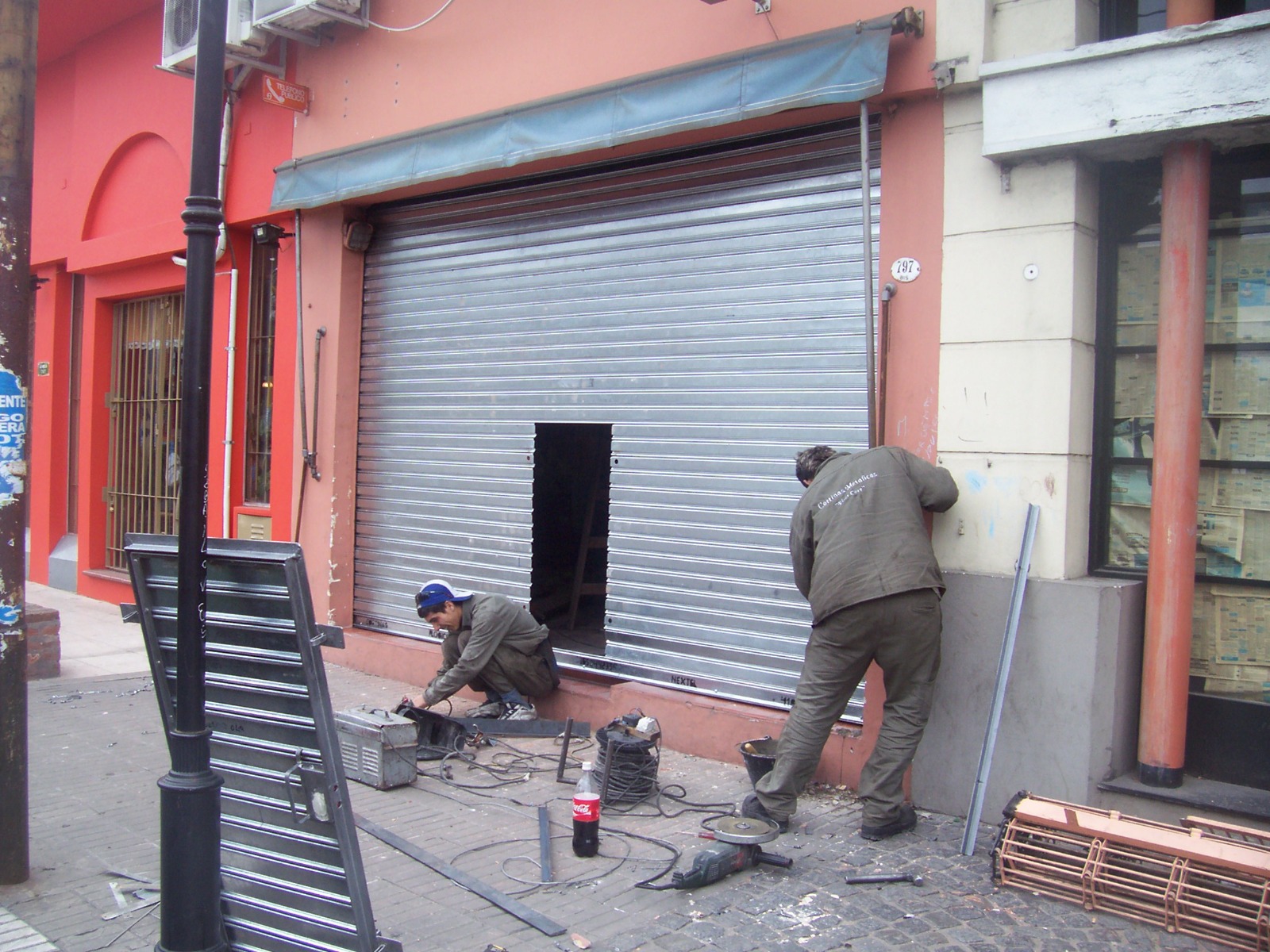 Técnicos de FlogiCort instalando una cortina metálica en un local comercial en Lanús